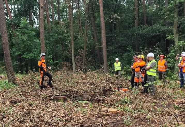 Zdjęcie&#x20;przedstawia&#x20;grupę&#x20;mężczyzn&#x20;stojących&#x20;w&#x20;lesie&#x20;podczas&#x20;prowadzonego&#x20;szkolenia&#x2e;&#x20;&#x28;fot&#x2e;&#x20;archiwum&#x20;nadleśnictwa&#x2c;&#x20;Z&#x2e;&#x20;Kubiak&#x29;